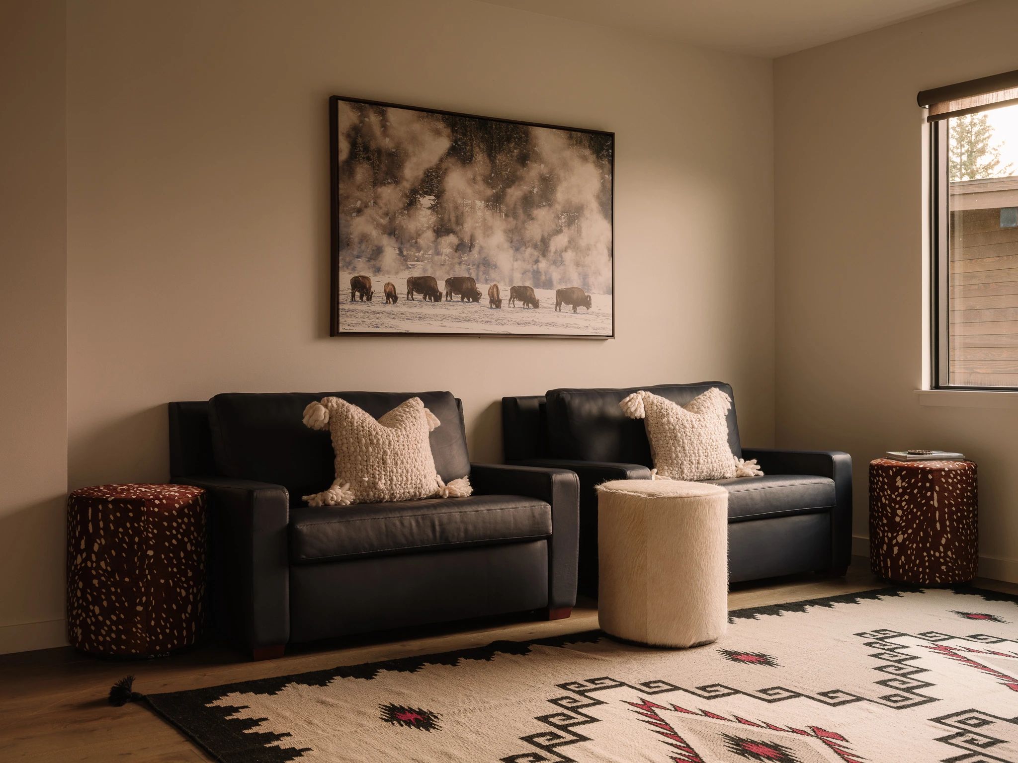 Sitting room with leather chairs and Western artwork — interior design photography Big Sky Montana, Speedwell Cabin